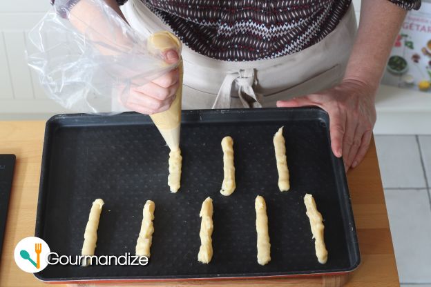 Pipe roughly 20 breadsticks onto a baking tray