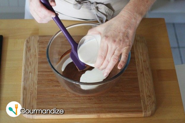 Pour 1/3 of the simmering cream mixture onto the melted chocolate and stir vigorously with a rubber spatula