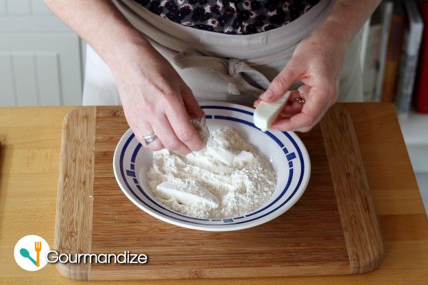 Dip each mozzarella stick in the flour and tap to remove any excess